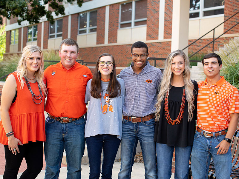 Six students standing with arms around each other
